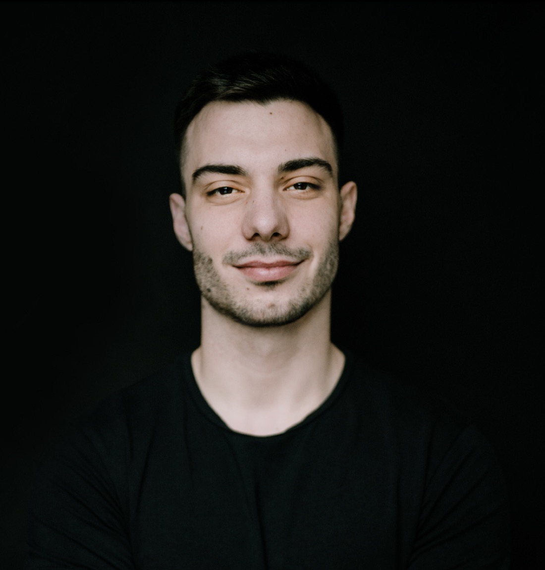 Viktor Madič in a black T-shirt against a black studio background